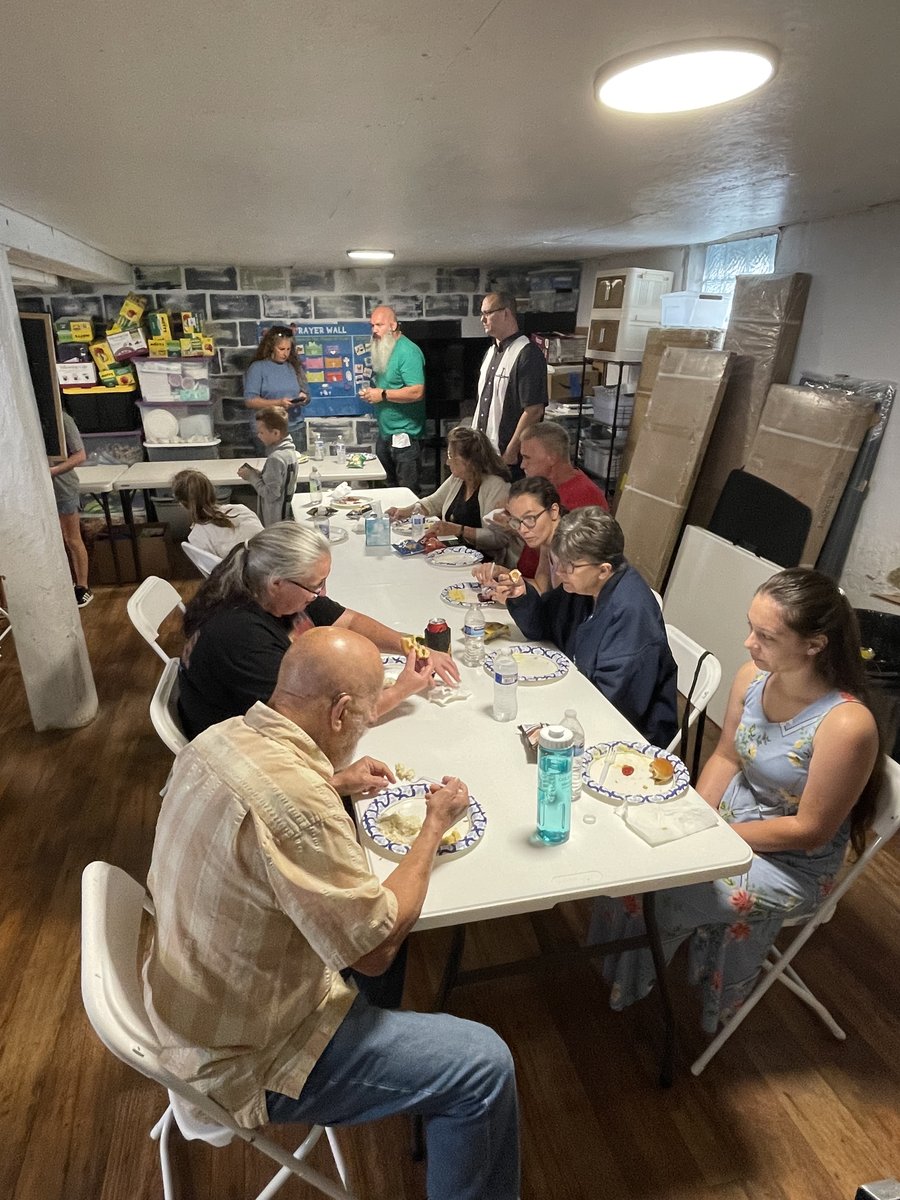 Church members eating together at folding tables in the fellowship hall
