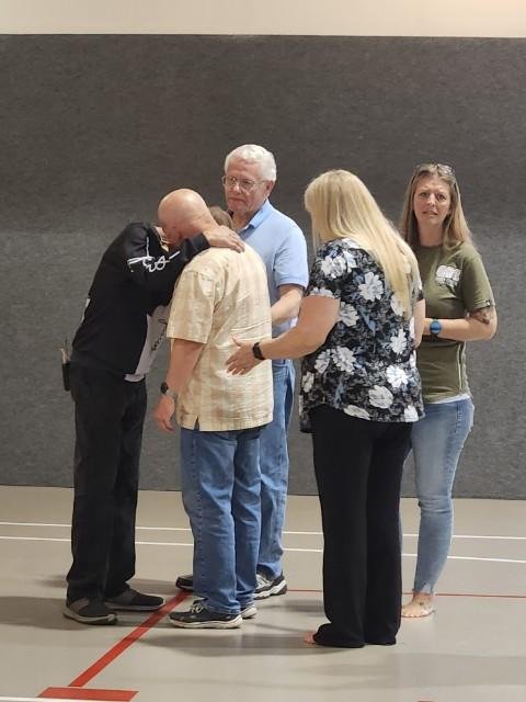 Church members praying together in a circle, hands joined