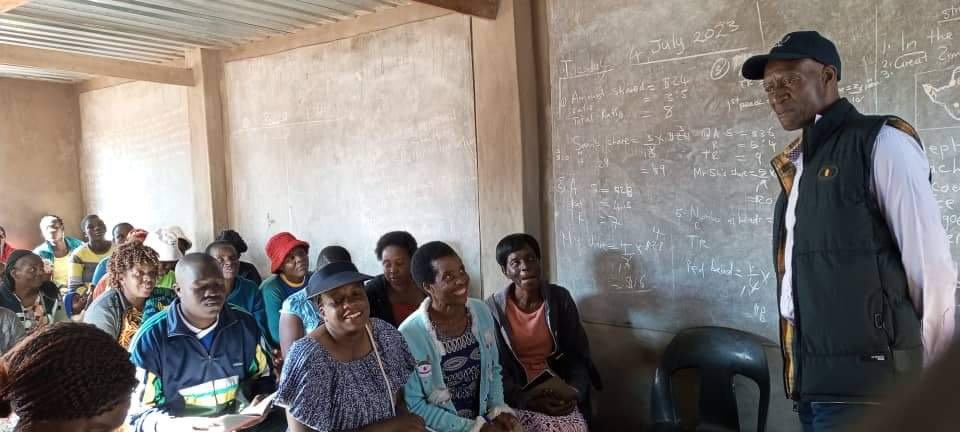 Community members gathered indoors in a brick meeting building