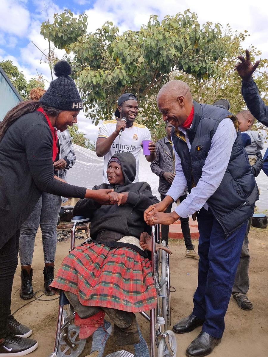 NFM team greeting an elderly wheelchair recipient during the Zimbabwe partnership visit
