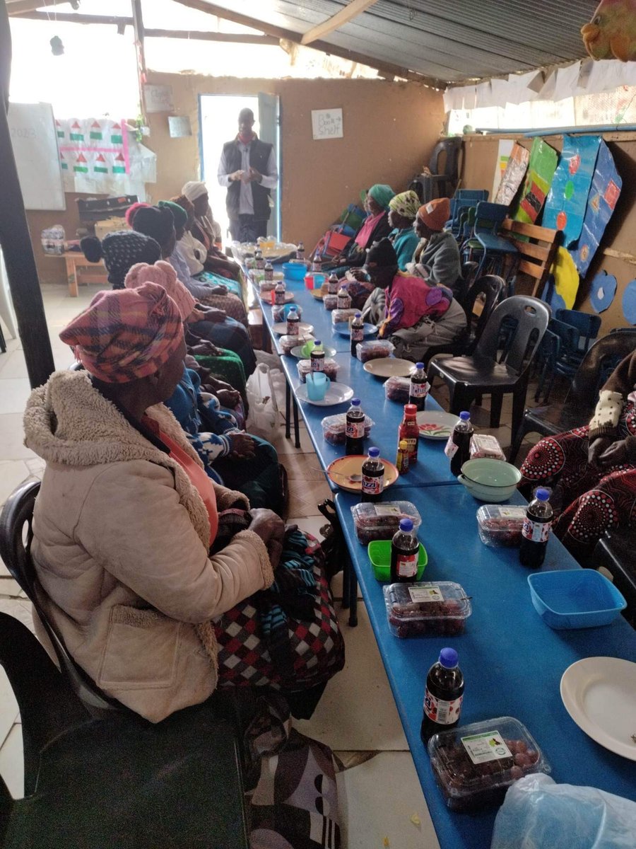Elderly community members seated together for a shared meal